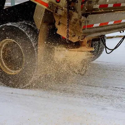 close-up of a truck spreading sand on the road